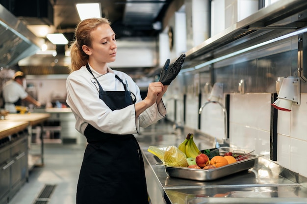 Cuoco unico femminile che indossa il guanto in cucina