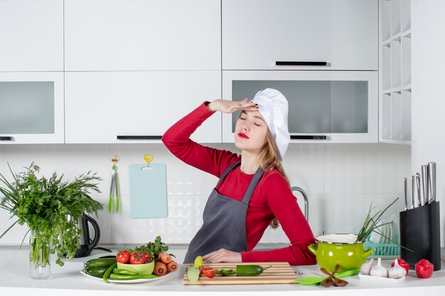 Cuoco unico femminile di vista frontale in cappello del cuoco che chiude gli occhi