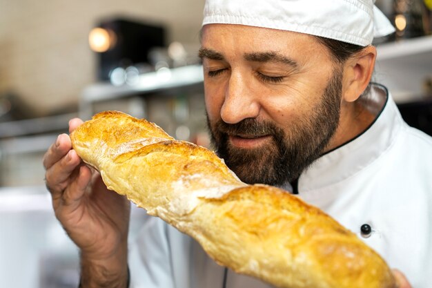 Cuoco unico maschio in cucina che sente l'odore del pane appena sfornato