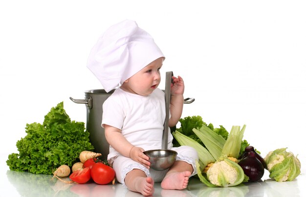 Cuoco unico sveglio del bambino con grande pentola e verdure