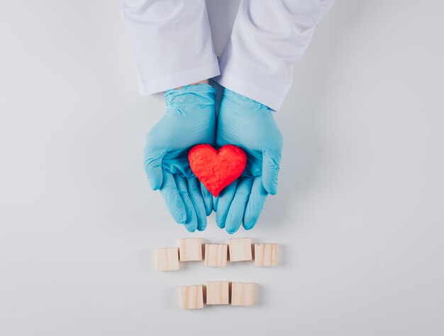 Cuore dentro le mani maschili con elementi in legno