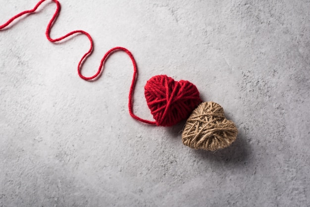 Cuore di filato rosso a forma di sullo sfondo del muro