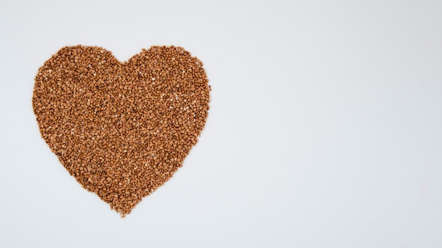 Cuore di grano saraceno su sfondo blu con copia-spazio