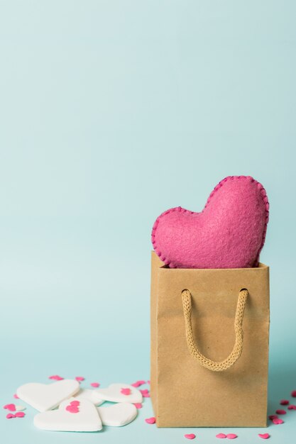 Cuore rosa in borsa artigianale vicino alle decorazioni