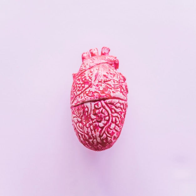 Cuore umano in ceramica rosa sul tavolo