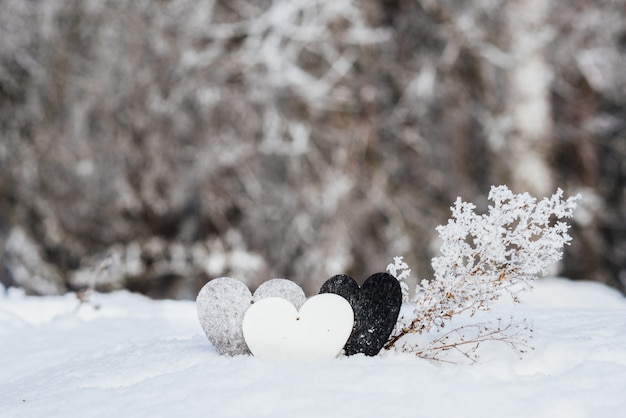 Cuori di San Valentino su sfondo di neve invernale. Concetto di giorno di San Valentino.