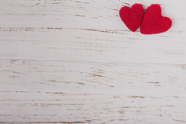 cuori di tessuto rosso su un tavolo di legno