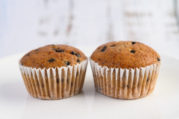 Cupcakes alla banana mescolati con gocce di cioccolato su un piatto bianco.