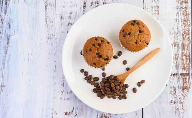 Cupcakes alla banana mescolati con gocce di cioccolato su un piatto bianco.