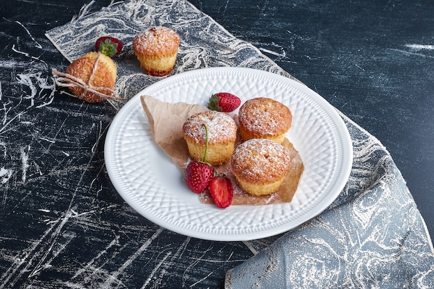 Cupcakes in un piatto bianco con frutti di bosco.