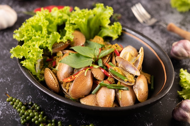 Curry fritto delle vongole su una banda nera.