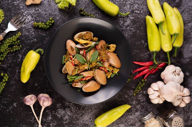 Curry fritto delle vongole su una banda nera.