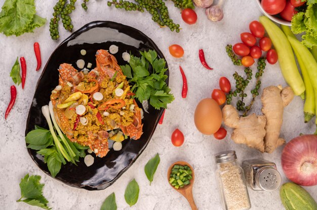 Curry in padella del granchio su una banda nera sul pavimento del cemento.