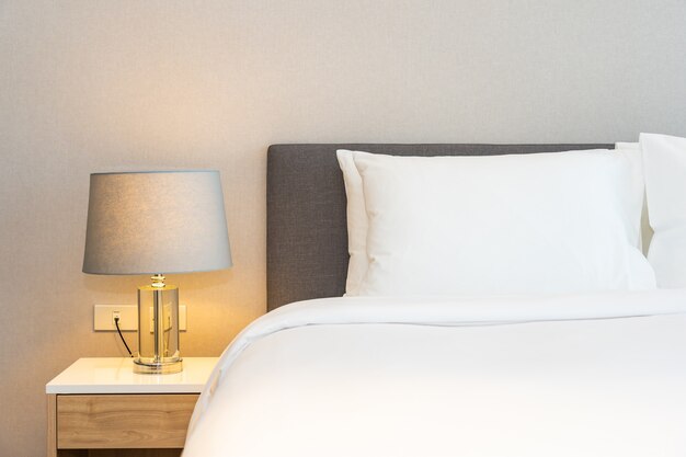 Cuscino bianco sul letto con lampada leggera