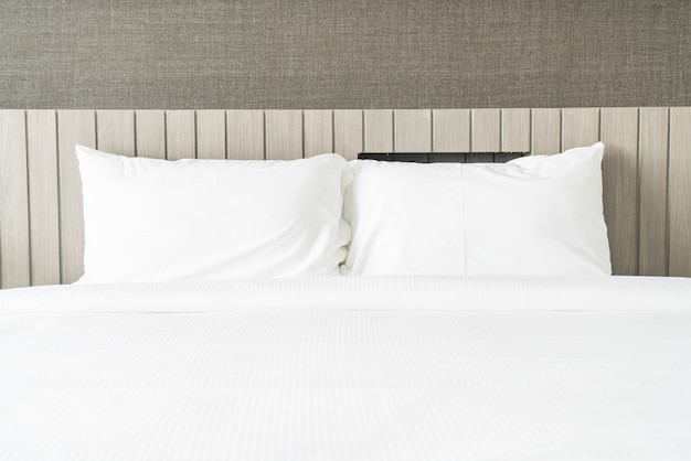 Cuscino bianco sulla decorazione letto in camera da letto