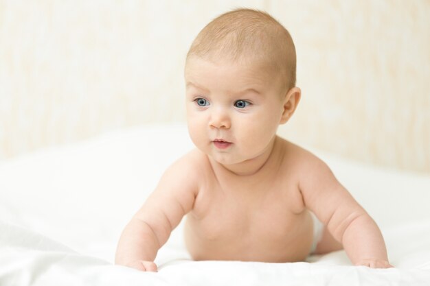 Cute neonato messo su un tummy solleva testa