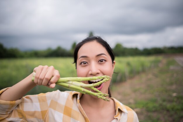 Da vicino il bel contadino raccoglie gli asparagi in mano e si avvicina alla telecamera.