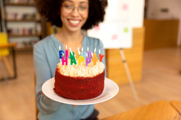 Da vicino una donna sorridente con una torta in mano