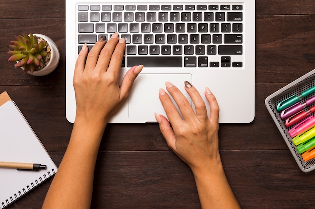 Dall'alto delle mani femminili che lavorano al computer portatile