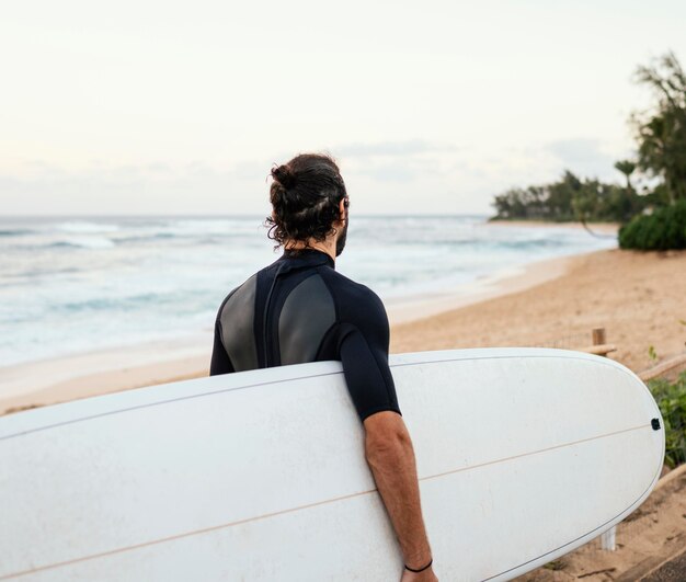 Dall'uomo surfista girato indietro all'aperto