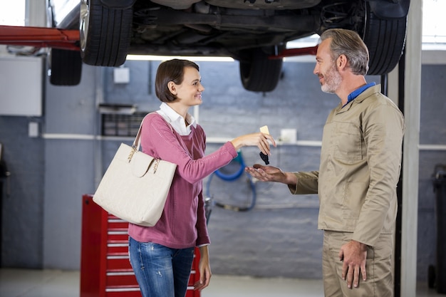 dando al cliente le chiavi dell&#39;auto al meccanico