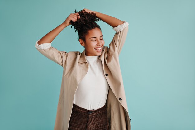 Debonair modello femminile in trench in posa con gli occhi chiusi