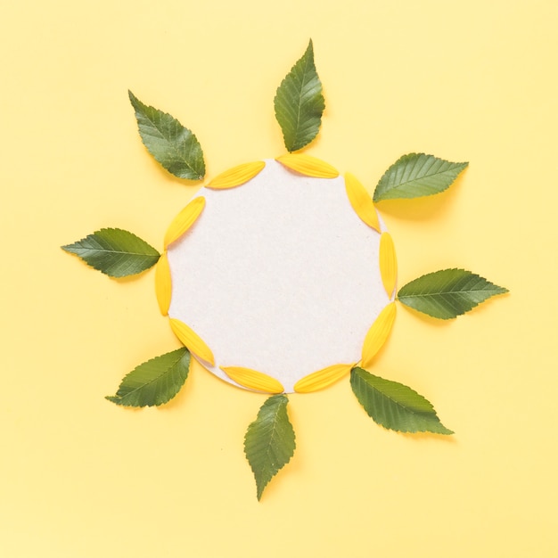 Decorazione a forma di girasole composta da foglie; petali e carta cartone bianca