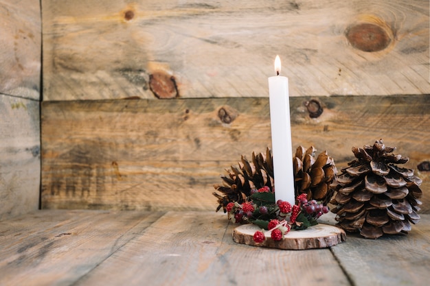 Decorazione autunnale con candele e coni di pino