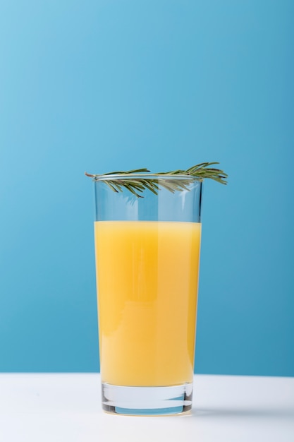 Decorazione con bicchiere di succo d'arancia ed erbe