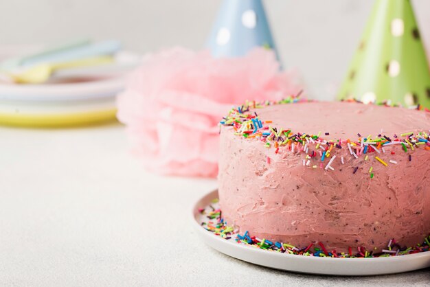 Decorazione con cappelli da festa e torta rosa