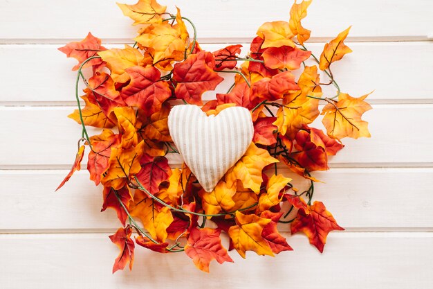 Decorazione d&#39;autunno con cuore su foglie d&#39;autunno