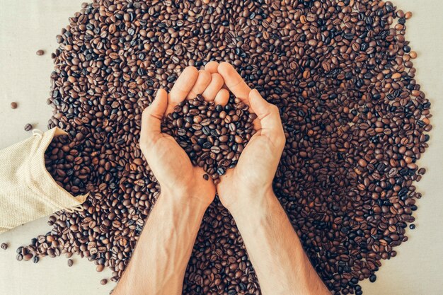 Decorazione di caffè con le mani azienda fagioli