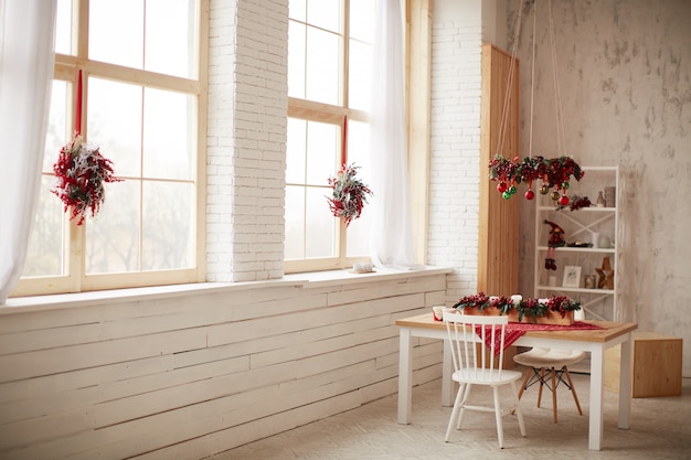 Decorazione di vacanze invernali Preparativi in studio Ghirlande fatte di bacche rosse e albero di Natale