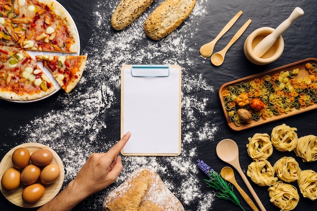 Decorazione italiana di cibo con dito che punta su appunti