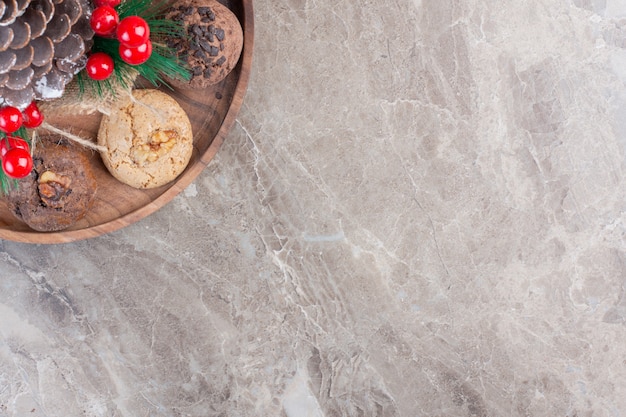 Decorazione natalizia al centro di un vassoio per biscotti su marmo.