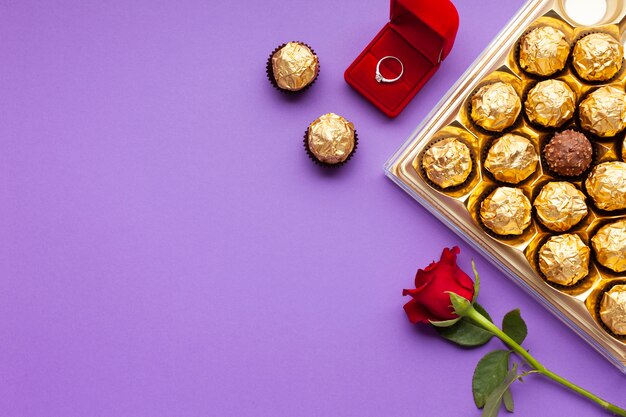 Decorazione vista dall'alto con anello, scatola di rose e cioccolato