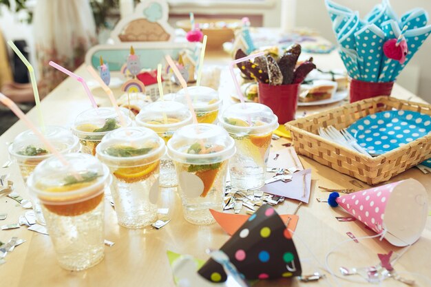 Decorazioni di compleanno per bambini. Tavola rosa dall'alto con torte, bibite e gadget per feste.