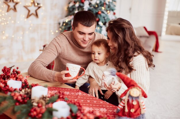 Decorazioni per le vacanze invernali Colori caldi. Ritratto di famiglia. Mamma, papà e la loro piccola figlia