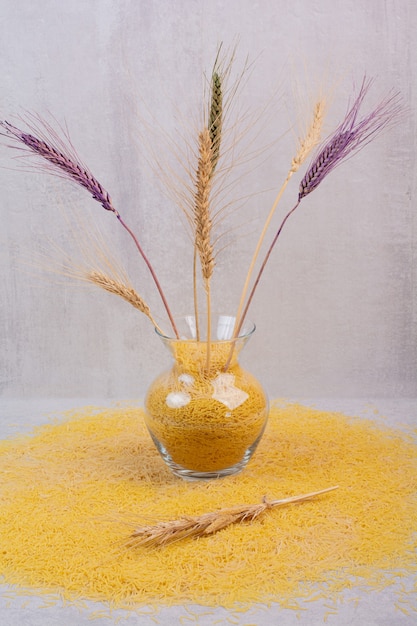 Delcious vermicelli gialli con vaso di grano.