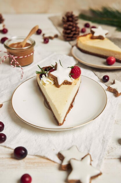 Deliziosa cheesecake natalizia con mirtilli rossi e stelle di biscotti su un tavolo bianco