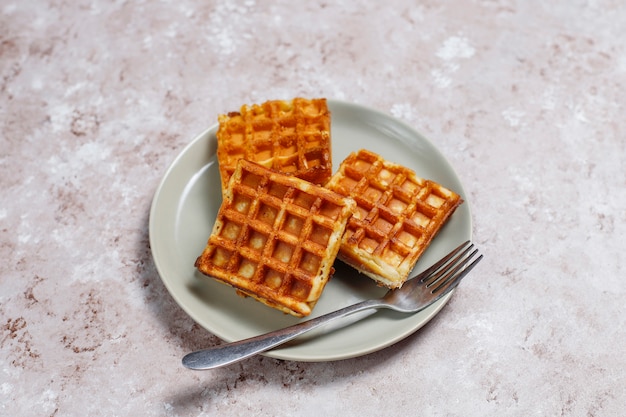 Deliziosa colazione con caffè, succo d'arancia, waffle, cornetti, marmellata, pasta di noci alla luce, vista dall'alto