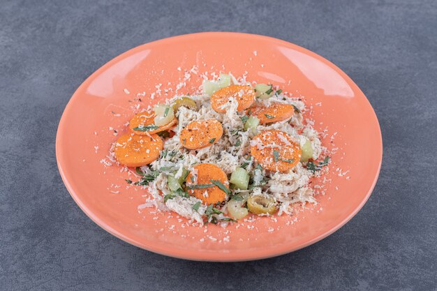 Deliziosa insalata di pollo sul piatto arancione.