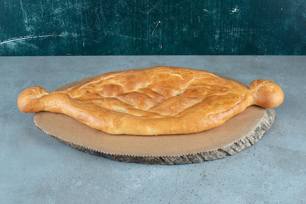 Deliziosa pagnotta di pane sul pezzo di legno.