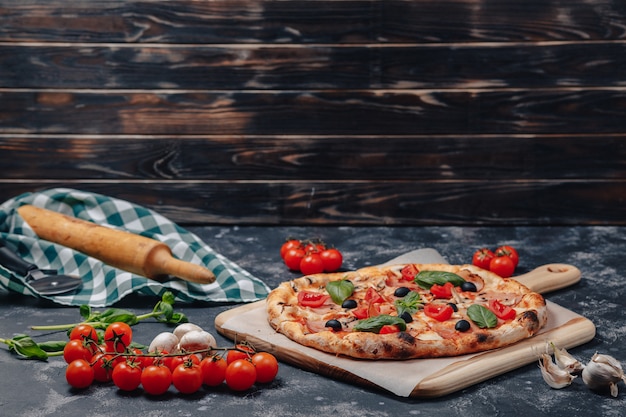 Deliziosa pizza napoletana a bordo con pomodorini, spazio libero per il testo