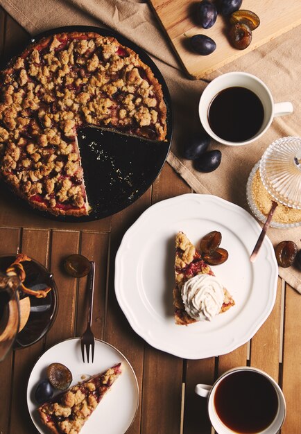 Deliziosa torta di prugne con caffè Chemex e ingredienti con tessuto su un tavolo in legno con tessuto