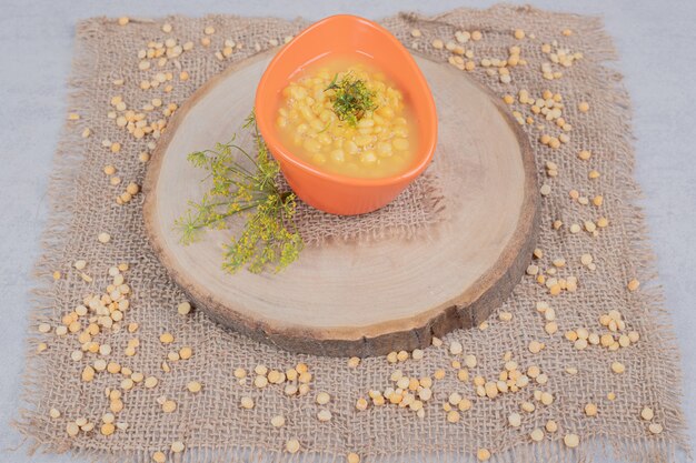 Deliziosa zuppa di lenticchie con chicchi di lenticchie sul piatto di legno.