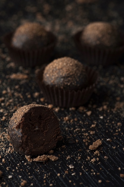 Deliziose caramelle al cioccolato con le briciole sulla superficie nera
