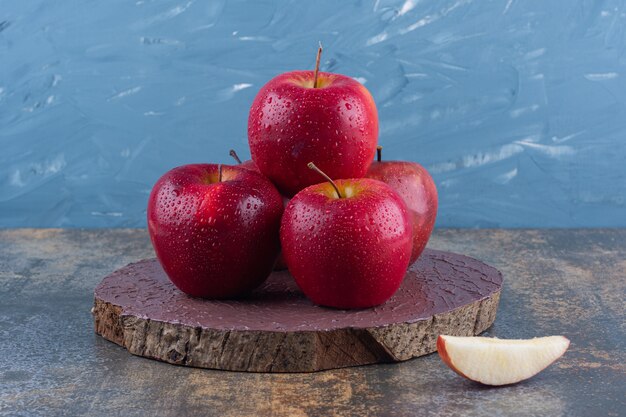 Deliziose mele rosse lucide poste sulla tavola di legno.