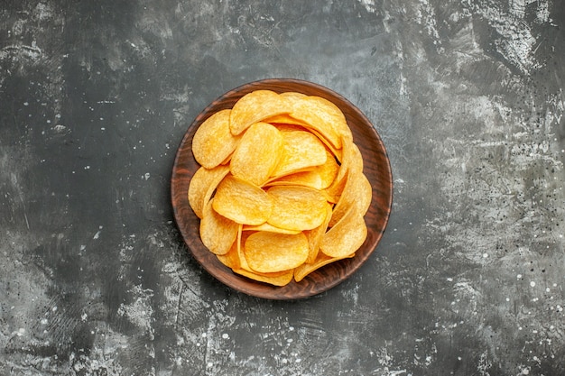 Deliziose patatine fatte in casa su un piatto marrone su immagine stock tavolo grigio