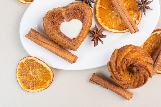 Deliziose torte, limone essiccato, anice e cannella su un piatto, sul marmo.